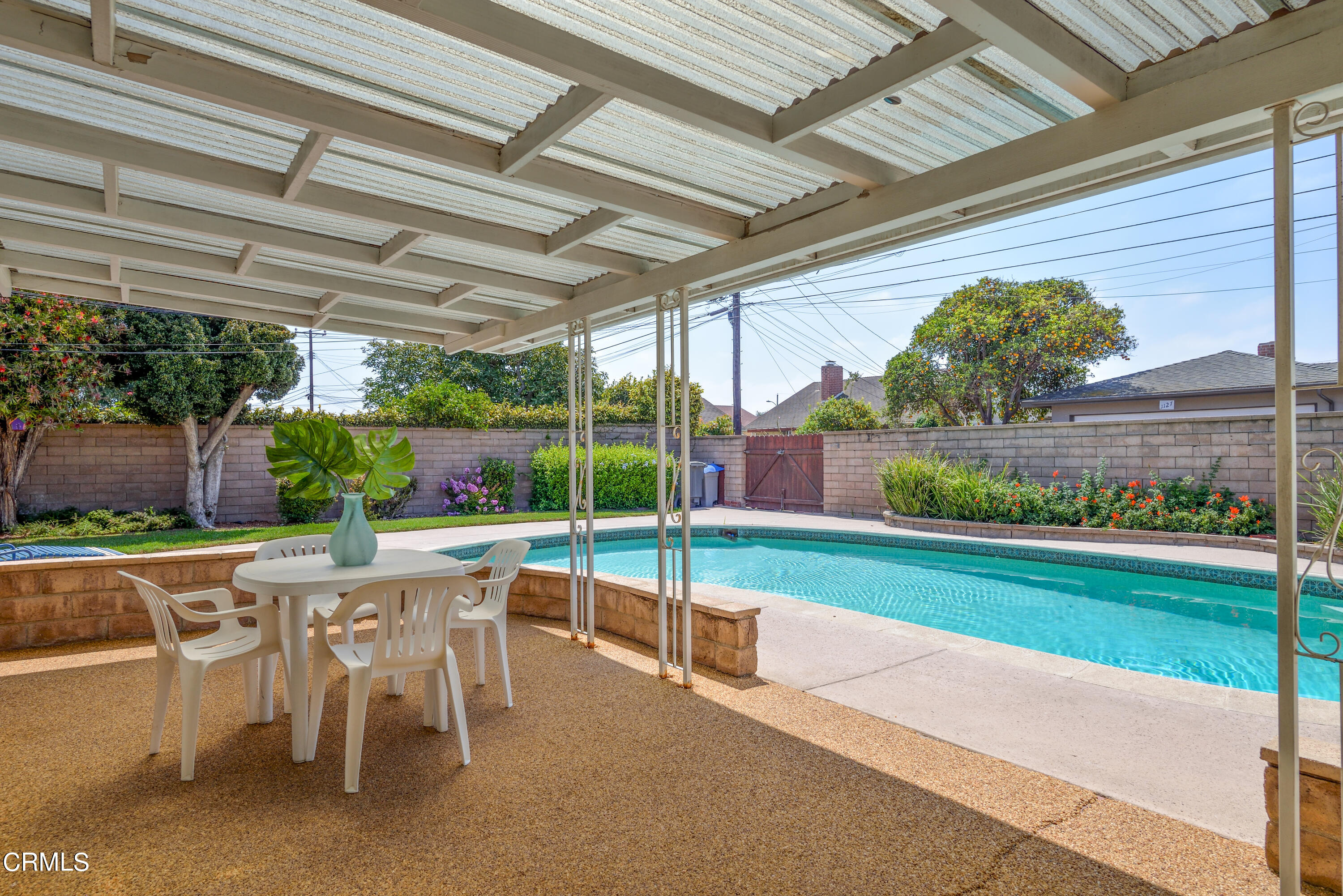 1126 West Roderick Avenue Oxnard, CA 93030 - Photo 22 of 28 a view of a patio with table and chairs potted plants with wooden floor and fence