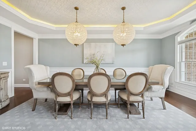a view of a dining room and livingroom with furniture wooden floor a chandelier