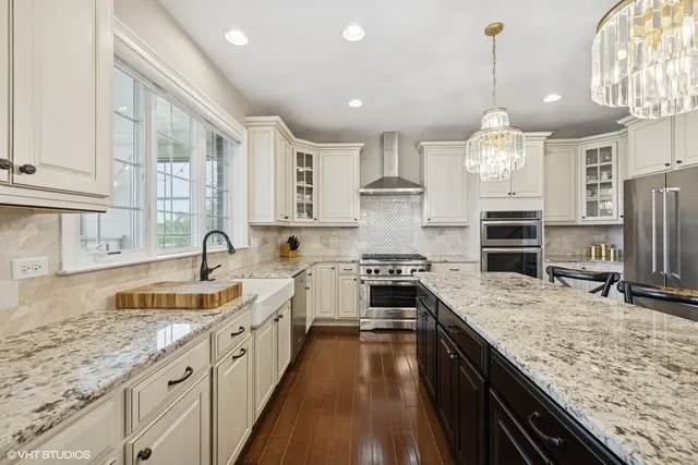 a view of a dining room and livingroom with furniture wooden floor a chandelier