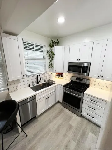 a kitchen with sink cabinets and stove top oven