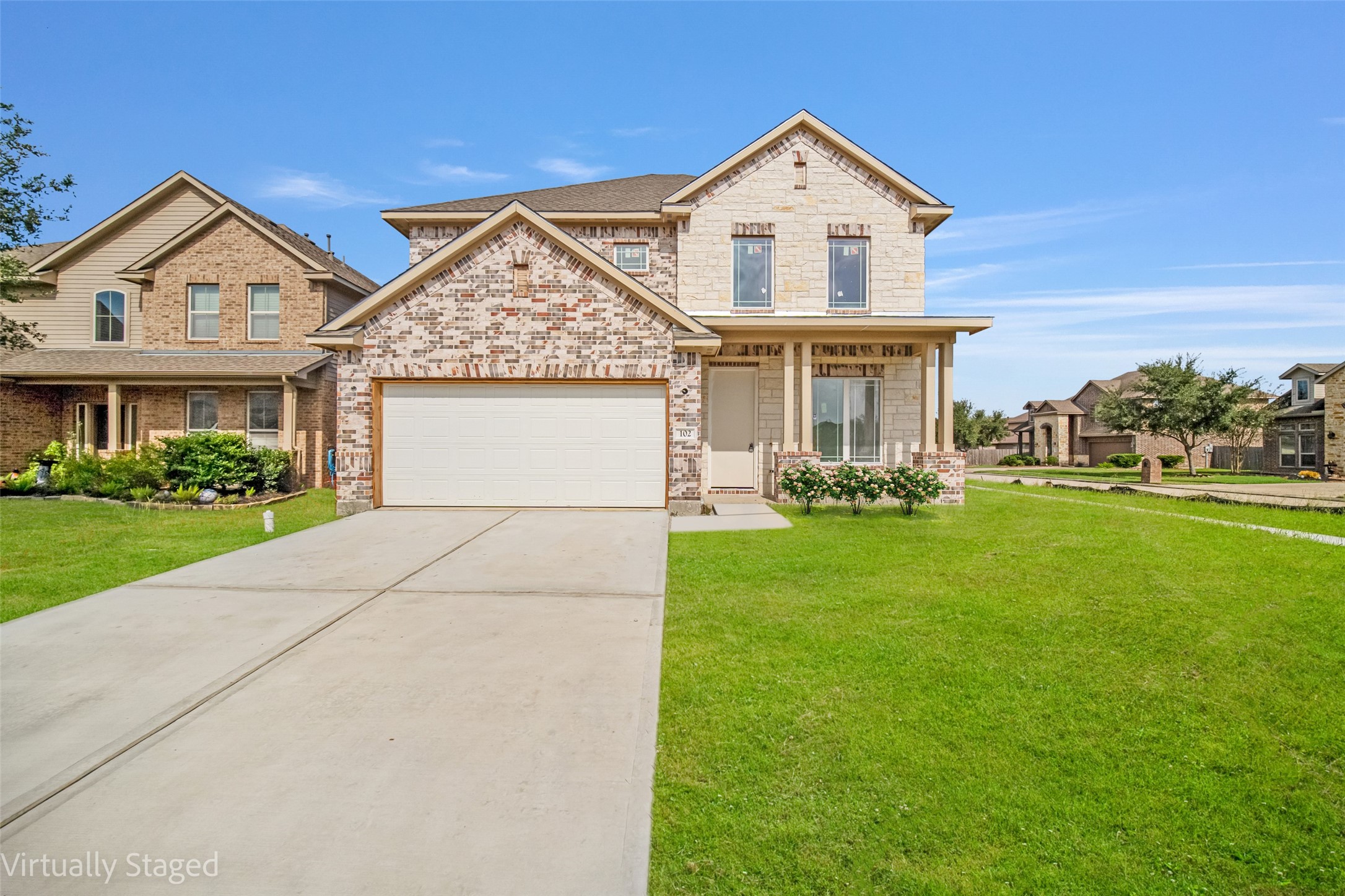 a front view of a house with a yard and garage