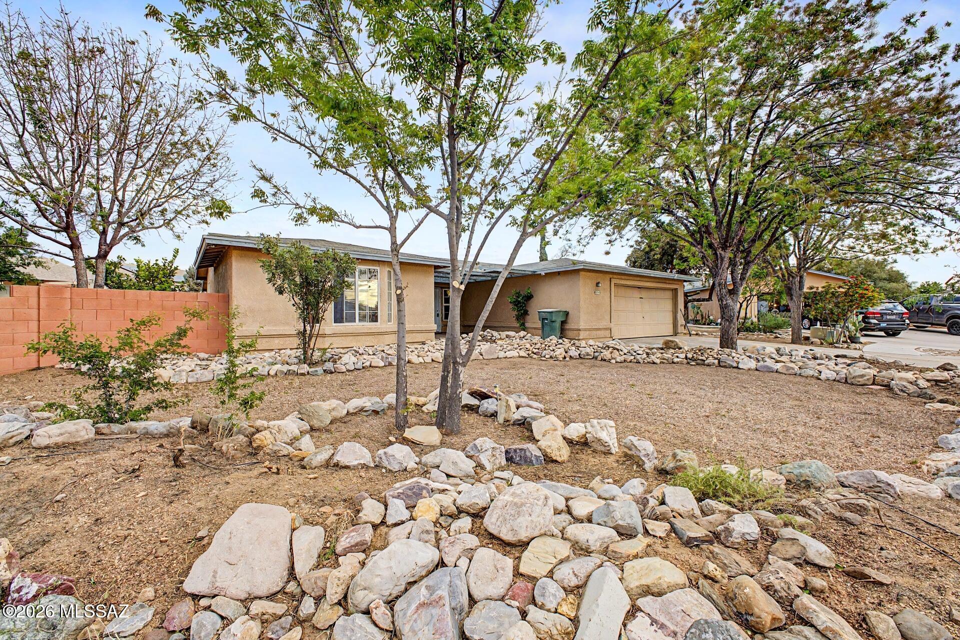 9810 East Stonehaven Way Tucson, AZ 85747 - Photo 3 of 27 a front view of a house with a yard covered in snow