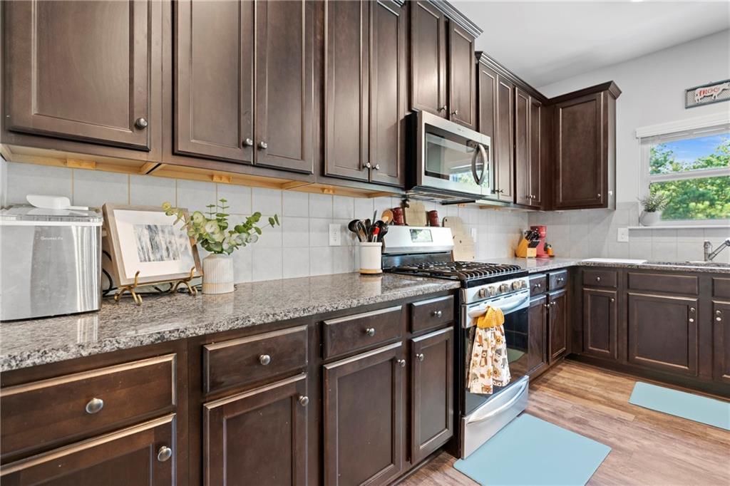 511 A Autumn Echo Canton, GA 30114 - Photo 8 of 39 a kitchen with granite countertop stainless steel appliances wooden cabinets a sink and a stove