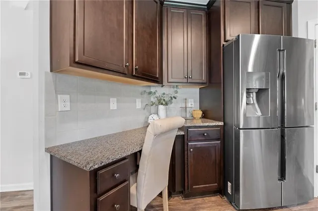 a kitchen with granite countertop wood cabinets stainless steel appliances and a sink