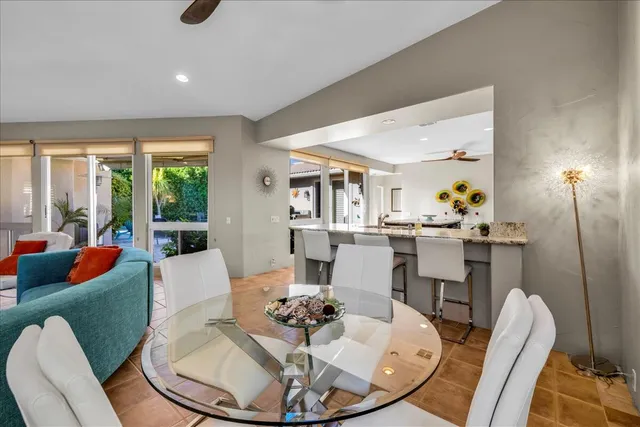 a dining room with furniture a large window and wooden floor