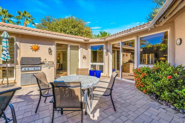 a patio with table and chairs and potted plants