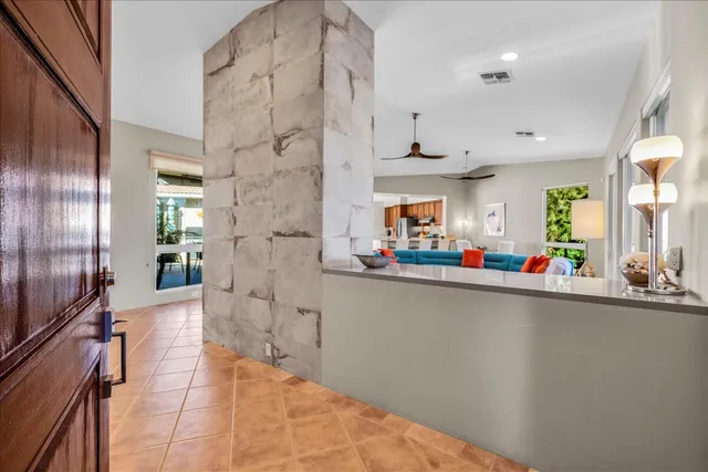 a view of a living room with stainless steel appliances furniture a refrigerator and a kitchen view
