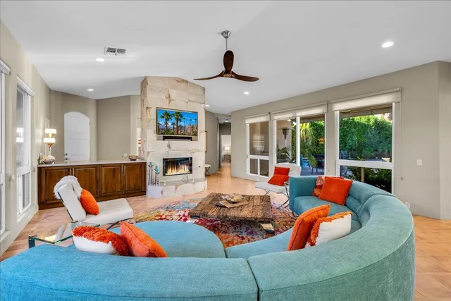 a living room with furniture fireplace and a large window