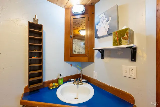 a bathroom with a granite countertop sink and a large mirror