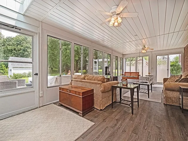 a living room with furniture two window and wooden floor