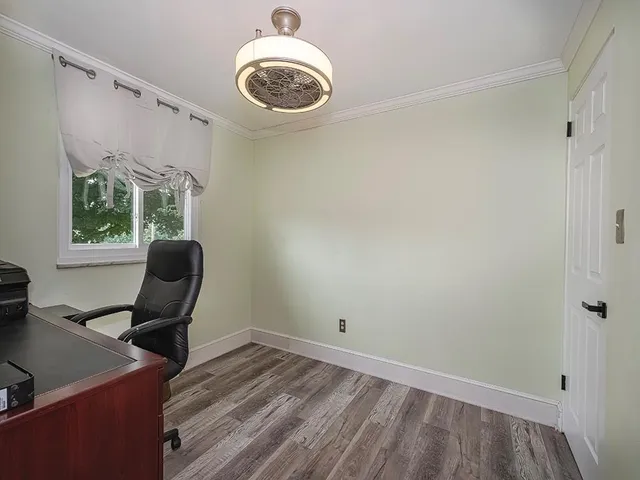 a view of a workspace with furniture and a window