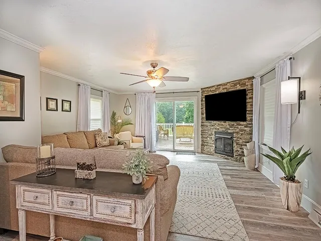 a living room with furniture a flat screen tv and a fireplace