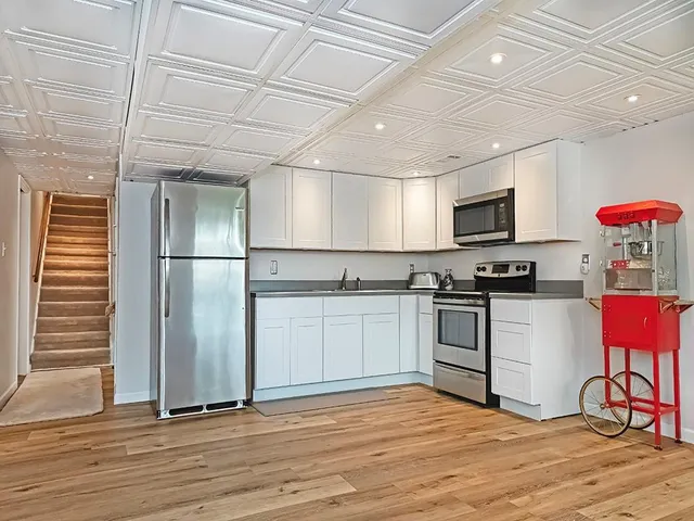 a kitchen with granite countertop a refrigerator stove top oven and sink