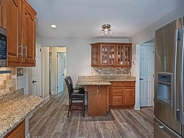 a kitchen with stainless steel appliances granite countertop a refrigerator and a stove top oven
