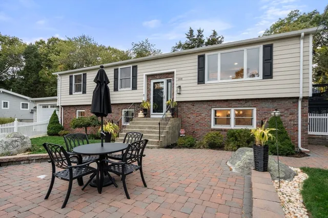 a kitchen with stainless steel appliances granite countertop a refrigerator a stove a dining table and chairs with wooden floor