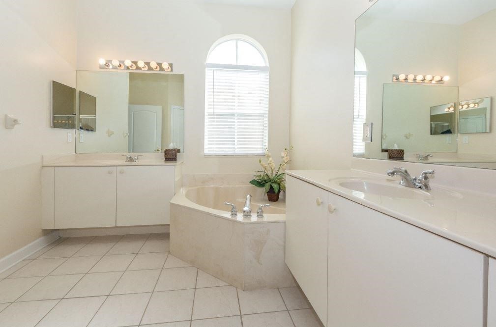 5825 Spanish River Road Fort Pierce, FL 34951 - Photo 14 of 36 a spacious bathroom with a bathtub sink and mirror
