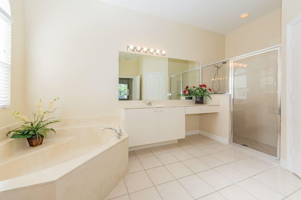 5825 Spanish River Road Fort Pierce, FL 34951 - Photo 15 of 36 a bathroom with a bathtub sink and mirror