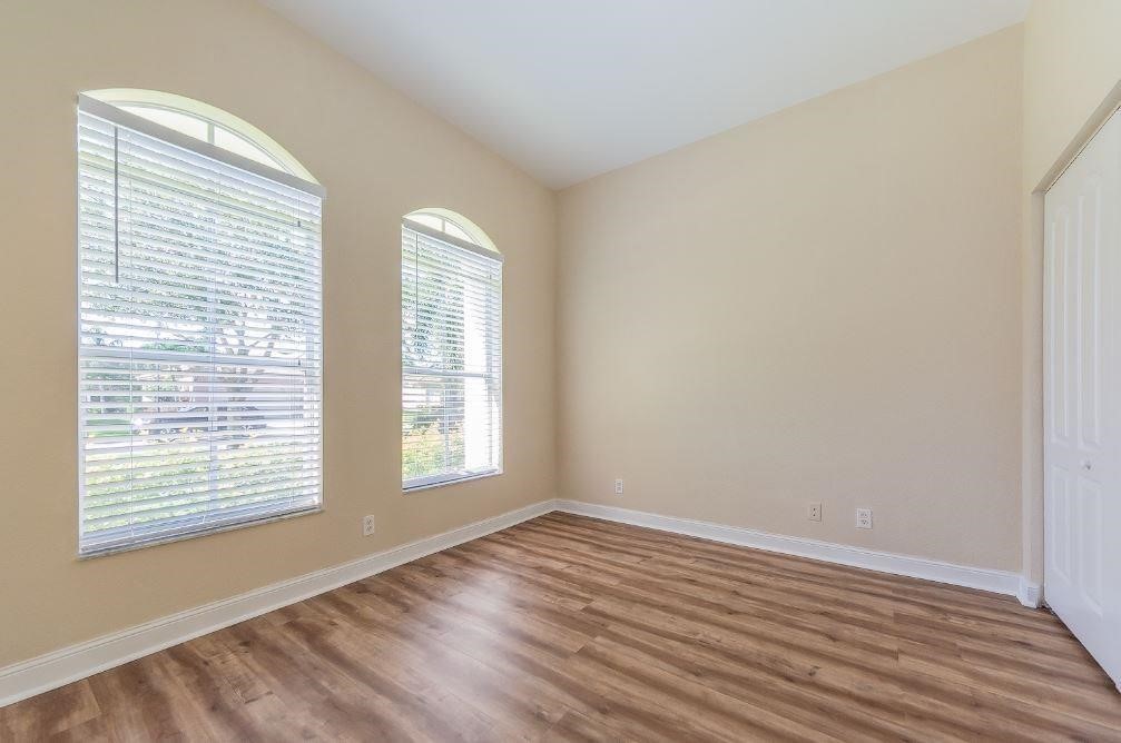 5825 Spanish River Road Fort Pierce, FL 34951 - Photo 16 of 36 a view of an empty room with wooden floor and a window