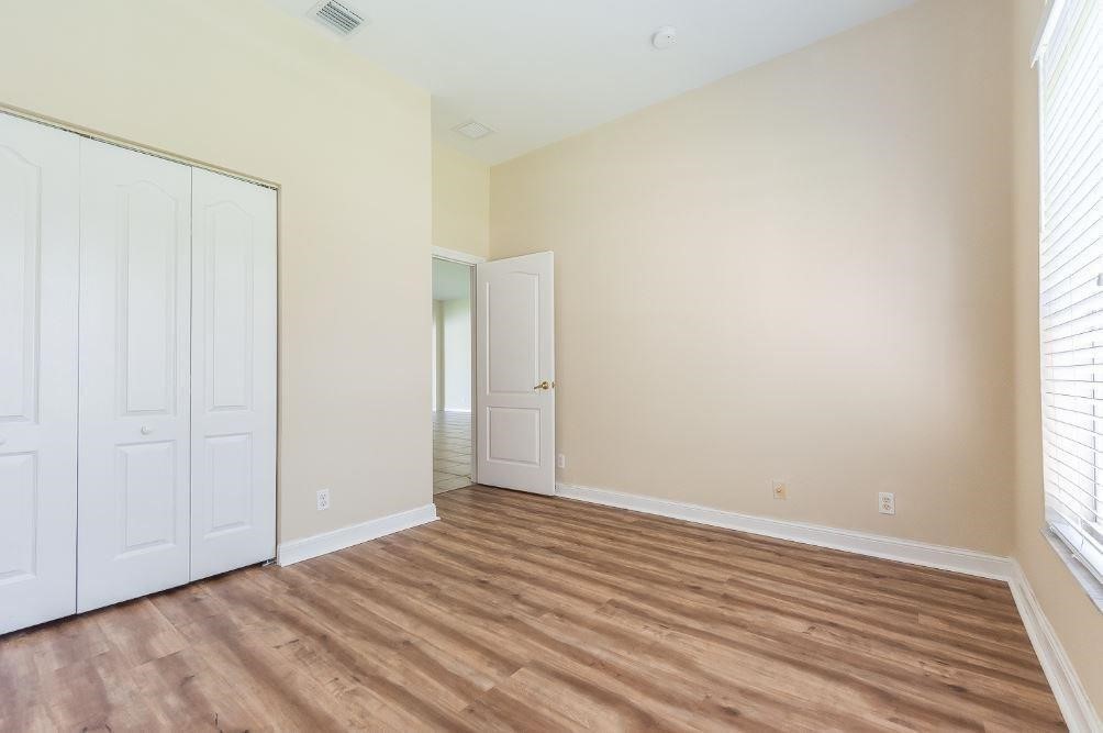 5825 Spanish River Road Fort Pierce, FL 34951 - Photo 17 of 36 a view of an empty room with wooden floor and a window