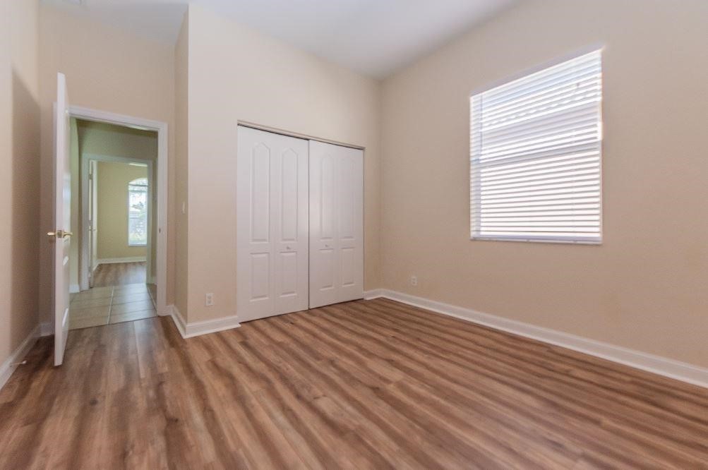 5825 Spanish River Road Fort Pierce, FL 34951 - Photo 19 of 36 a view of an empty room with wooden floor and a window