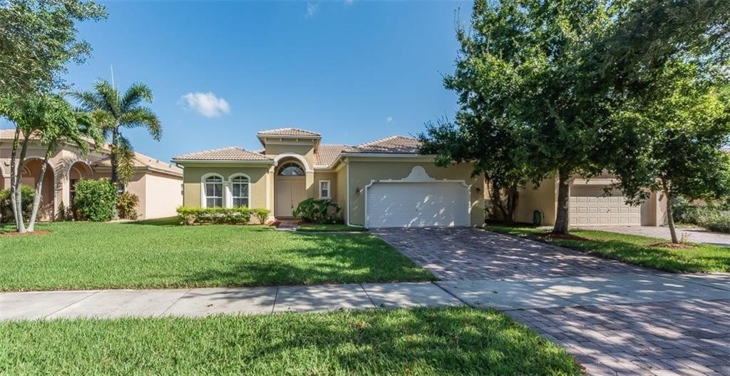 5825 Spanish River Road Fort Pierce, FL 34951 - Photo 3 of 36 a front view of a house with a garden