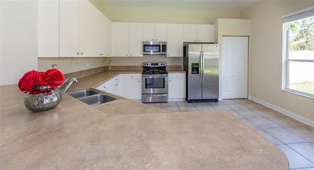 5825 Spanish River Road Fort Pierce, FL 34951 - Photo 6 of 36 a kitchen with stainless steel appliances granite countertop a refrigerator and a sink