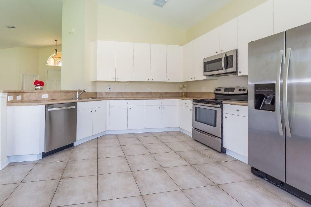 5825 Spanish River Road Fort Pierce, FL 34951 - Photo 8 of 36 a kitchen with stainless steel appliances granite countertop a sink and cabinets