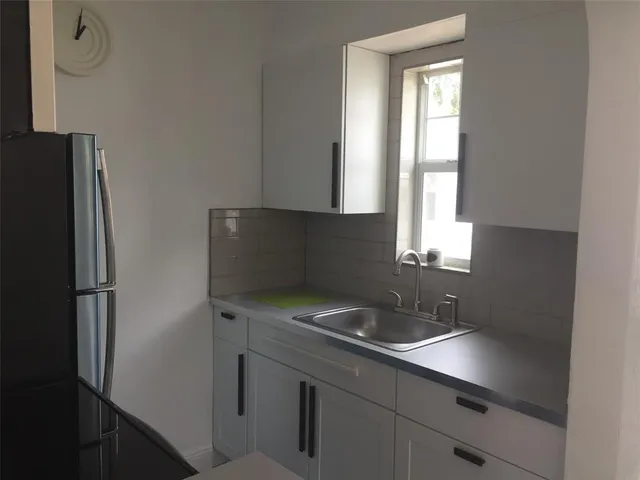 a kitchen with a refrigerator and a sink