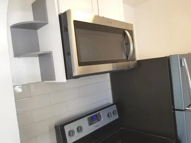 a utility room with closet and mirror