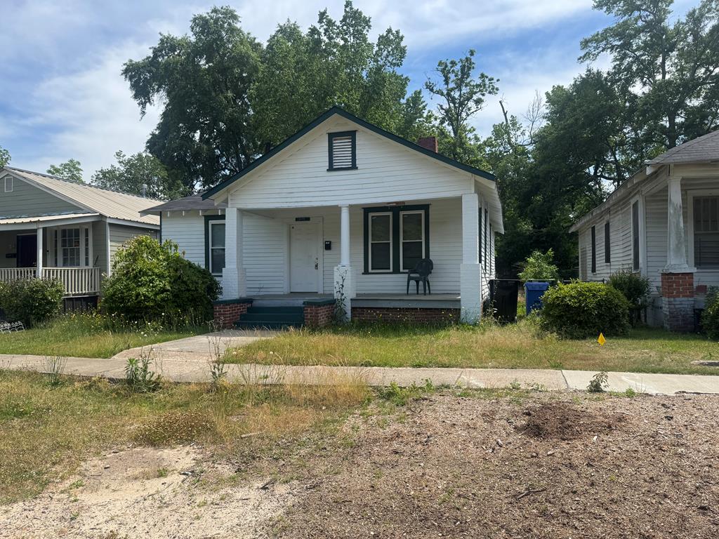 a front view of house with yard and trees around