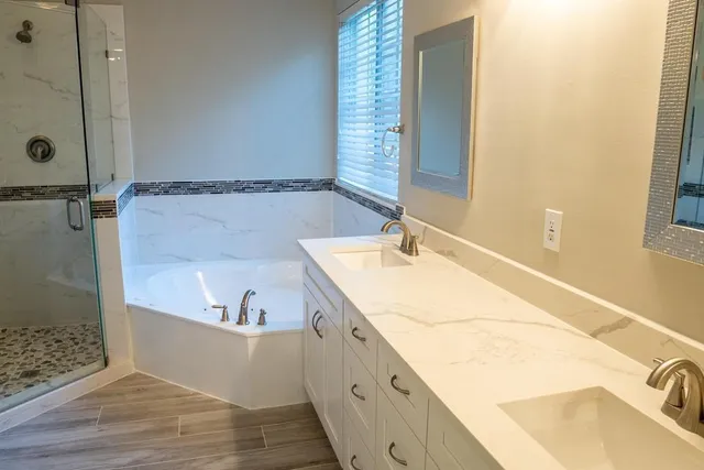a bathroom with a tub sink and mirror