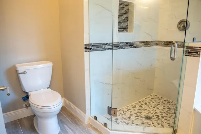 a bathroom with a toilet and a shower