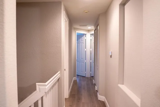 a view of a hallway with wooden floor