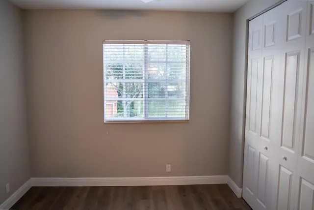an empty room with wooden floor and a window