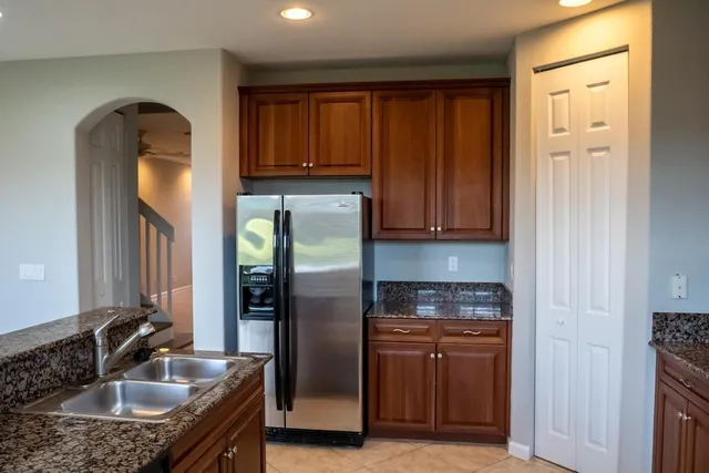 a kitchen with stainless steel appliances granite countertop a refrigerator and a sink