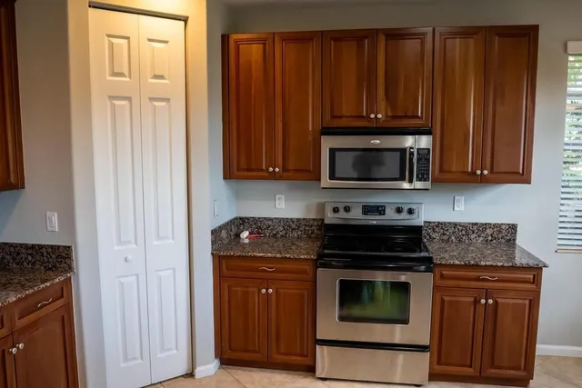 a kitchen with granite countertop wood cabinets and stainless steel appliances