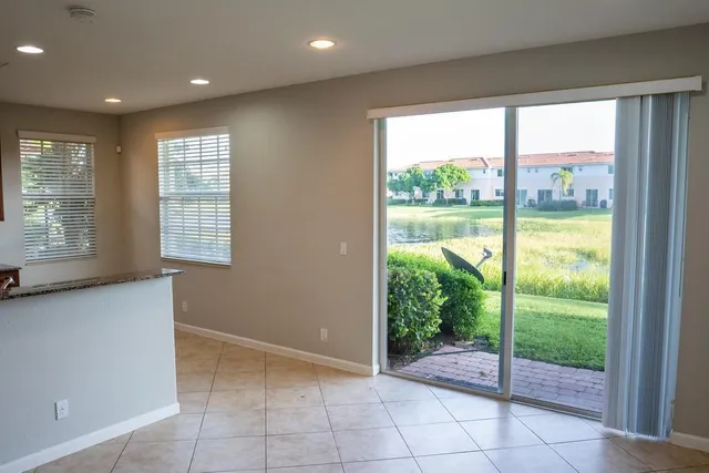 a view of an empty room with wooden floor and a floor to ceiling window