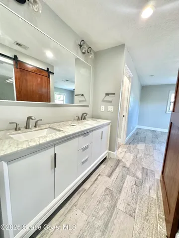 a spacious bathroom with a sink double vanity and mirror