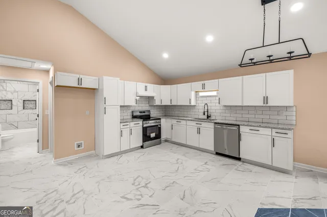 a kitchen with stainless steel appliances granite countertop a sink stove and cabinets