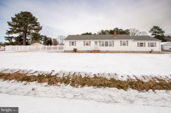 a front view of a house with a yard covered in snow