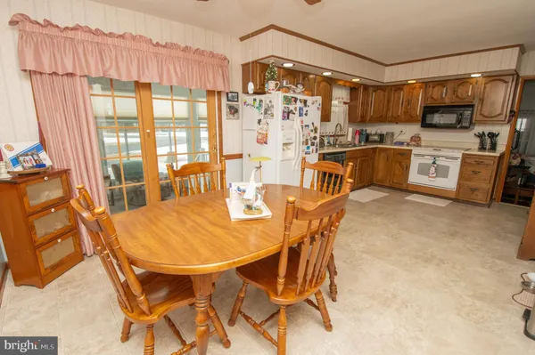 a dining room with stainless steel appliances a table and chairs