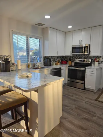 a kitchen with kitchen island a stove a sink a counter space and dining table