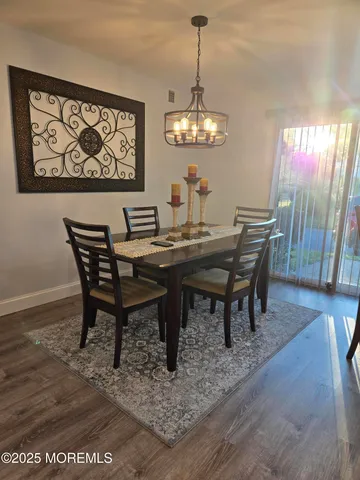 a view of a dining room with furniture wooden floor and a chandelier