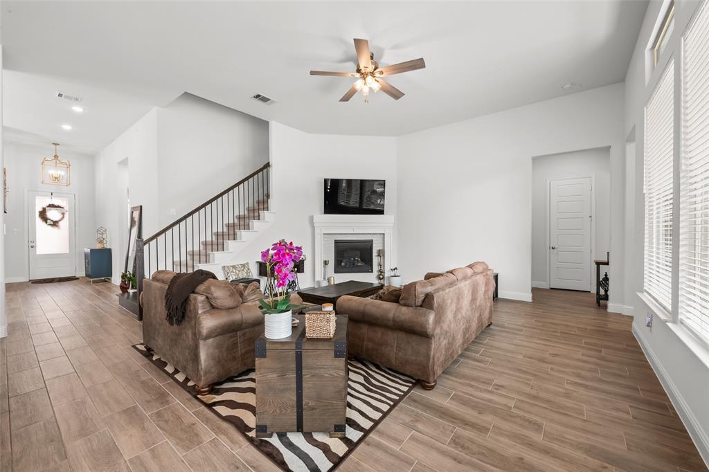 1712 Birch Street Mansfield, TX 76063 - Photo 7 of 35 a living room with furniture a fireplace and a chandelier