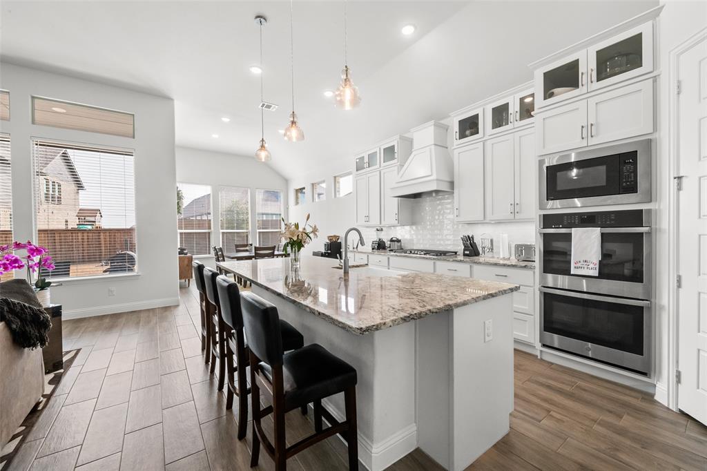 1712 Birch Street Mansfield, TX 76063 - Photo 10 of 35 a kitchen with stainless steel appliances kitchen island granite countertop a table chairs sink and cabinets