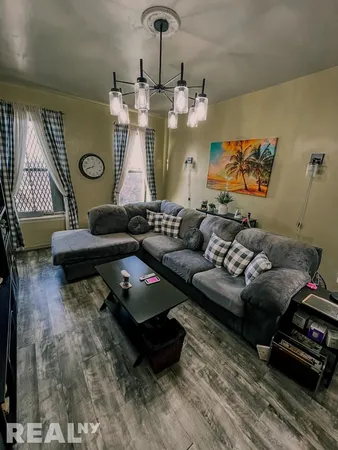 a living room with furniture and a chandelier