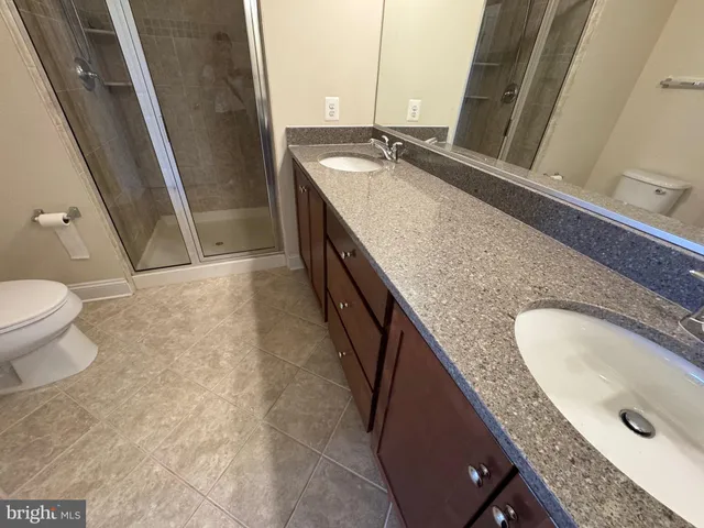 a bathroom with a granite countertop sink a toilet and a tub