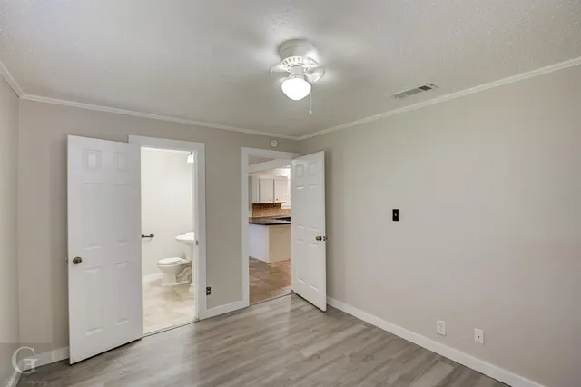 a view of a room with wooden floor and a ceiling fan