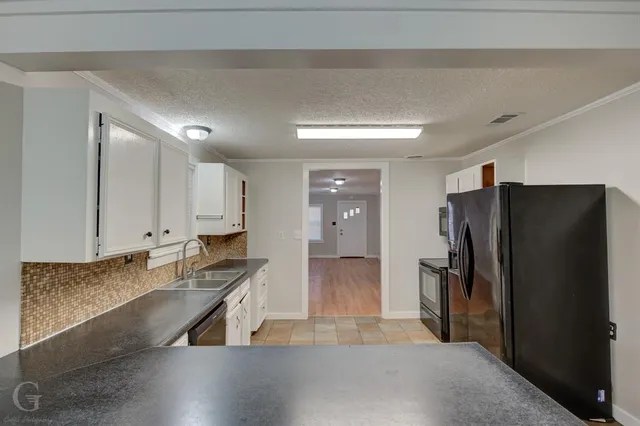 a kitchen with granite countertop a refrigerator and a sink