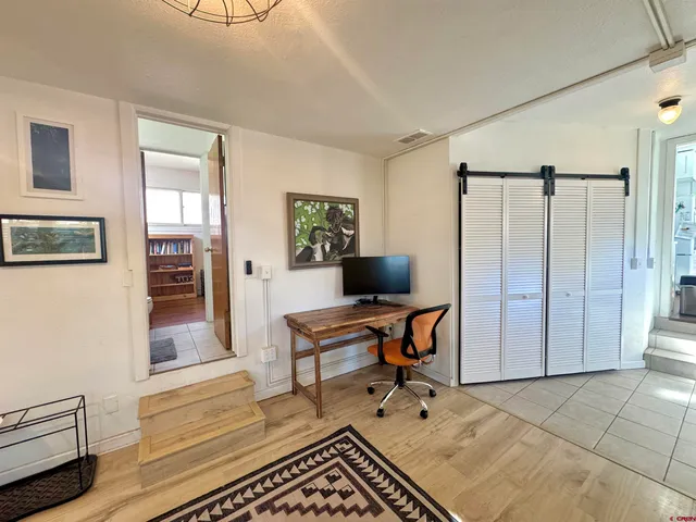 a workspace with wooden floor and a window
